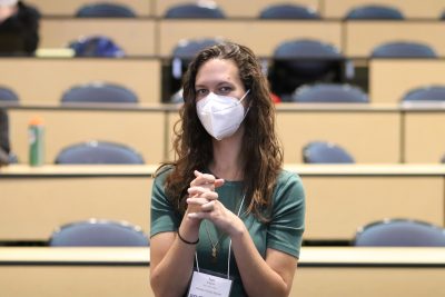 Tori Wagner (green short sleeved shirt, gold chain necklace) seated in ITE C80, hands clasped in front of her while looking at the camera